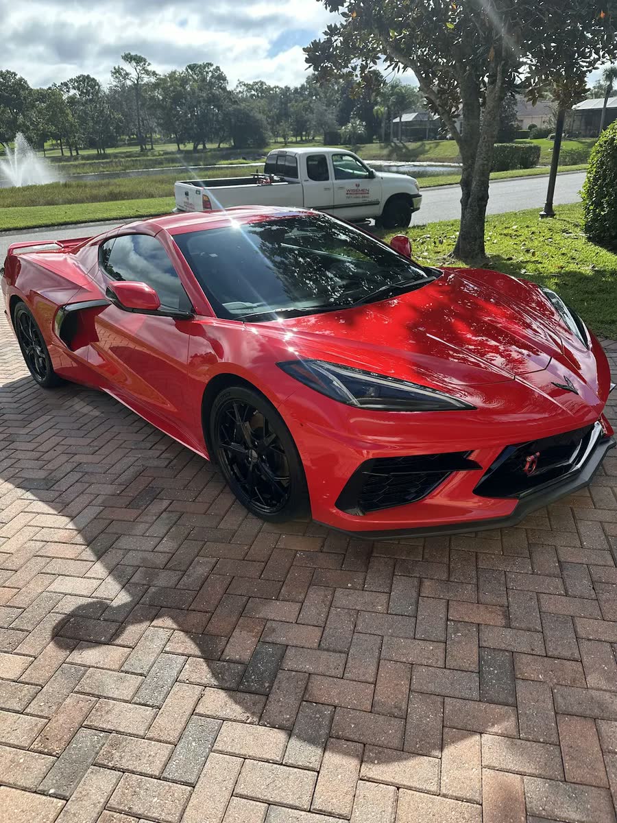 Glossy red Corvette on a paver driveway after a Wisemen detail